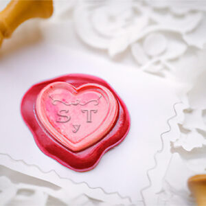 Sello de lacre para boda personalizado con forma de corazón con las letras S y T de color rosa